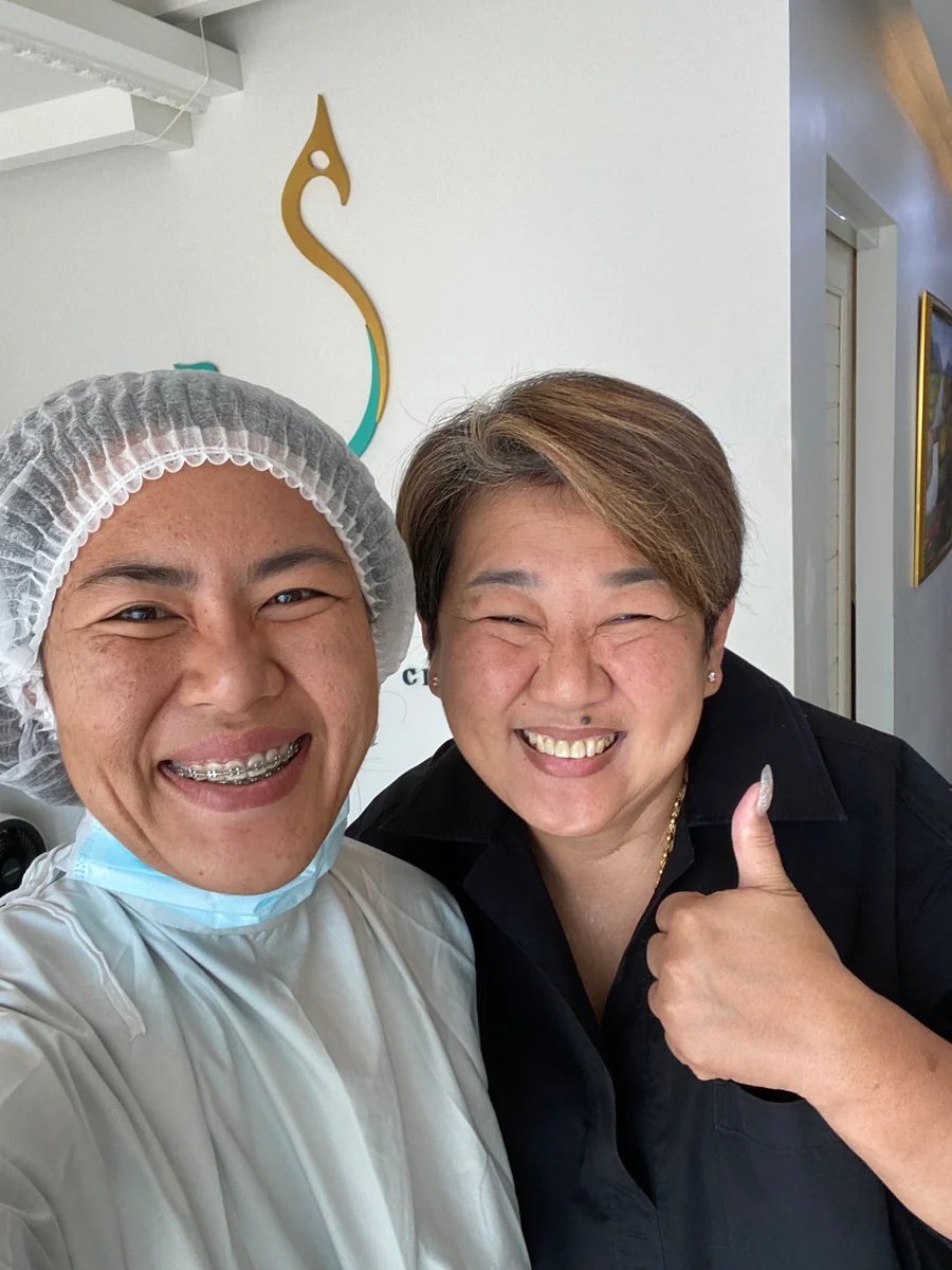 ทีมงานคลินิกและผู้มาใช้บริการยิ้มและถ่ายภาพร่วมกันภายในคลินิก Saldra Artua